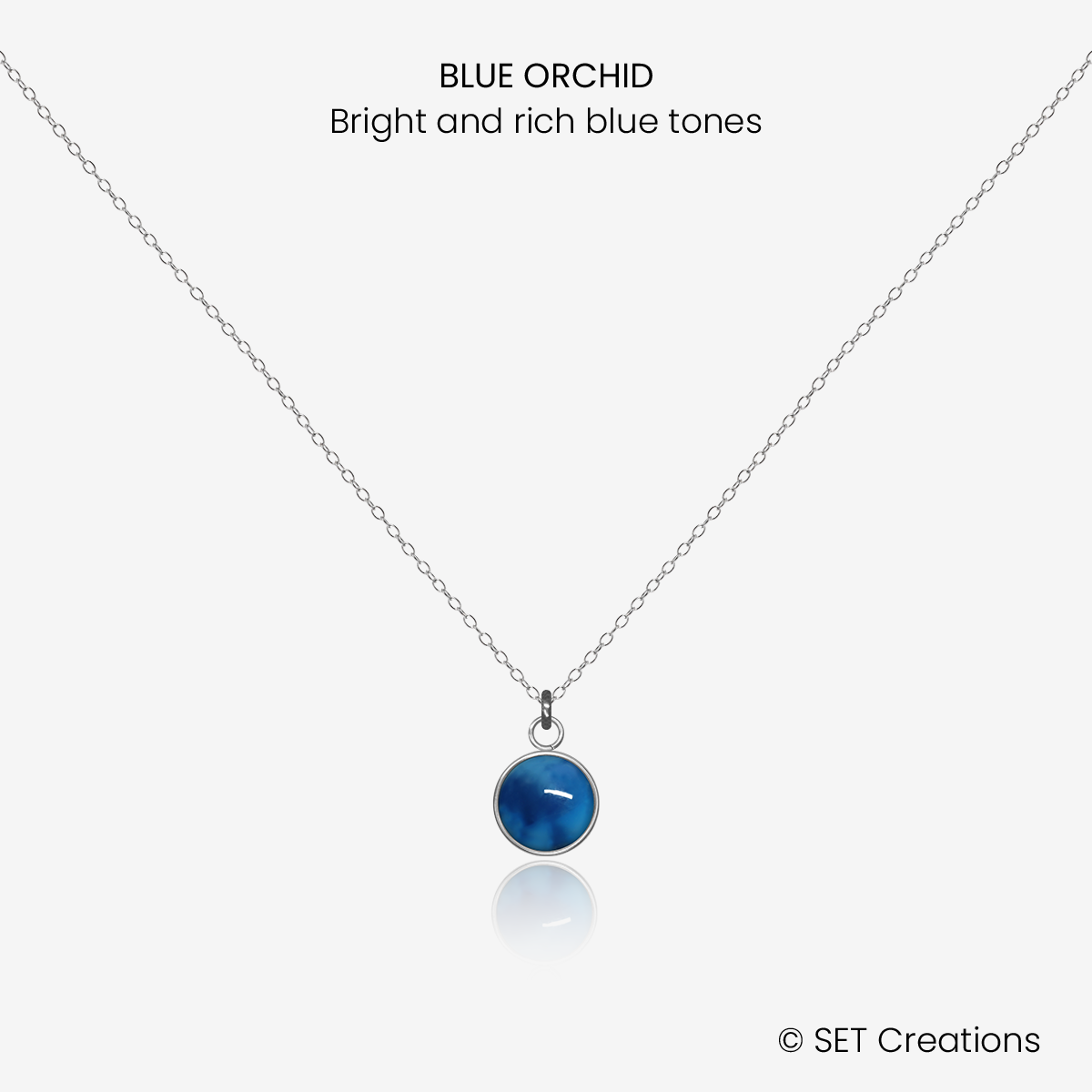 6mm fused glass circular cabochon set into a steel base and attached to a 400mm stainless steel pendant chain via jump ring. Cabochon colour: Blue Orchid = bright and rich blue marble effect.