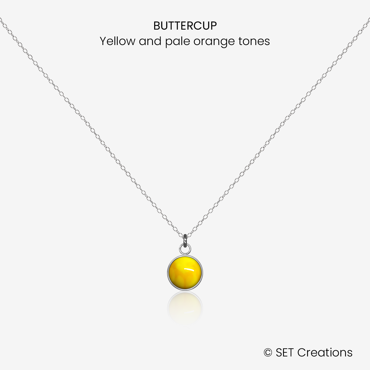 6mm fused glass circular cabochon set into a steel base and attached to a 400mm stainless steel pendant chain via jump ring. Cabochon colour: Buttercup = yellow and pale orange marble effect.
