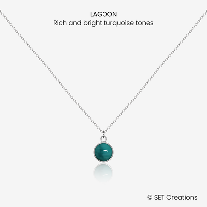 6mm fused glass circular cabochon set into a steel base and attached to a 400mm stainless steel pendant chain via jump ring. Cabochon colour: Lagoon = rich and bright turquoise marble effect.