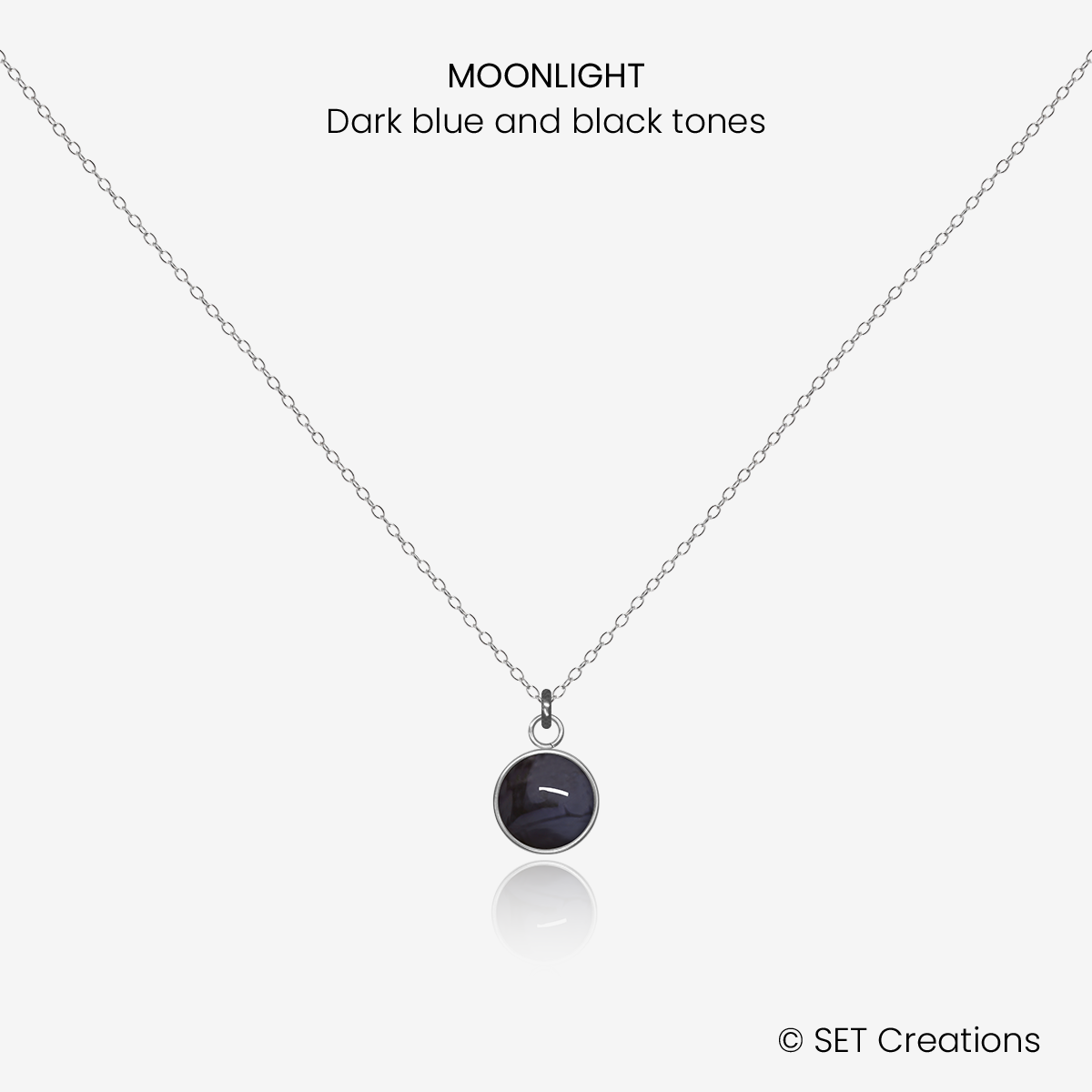 6mm fused glass circular cabochon set into a steel base and attached to a 400mm stainless steel pendant chain via jump ring. Cabochon colour: Moonlight = dark blue and black marble effect.