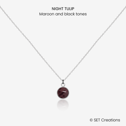 6mm fused glass circular cabochon set into a steel base and attached to a 400mm stainless steel pendant chain via jump ring. Cabochon colour: Night Tulip = maroon and black marble effect.