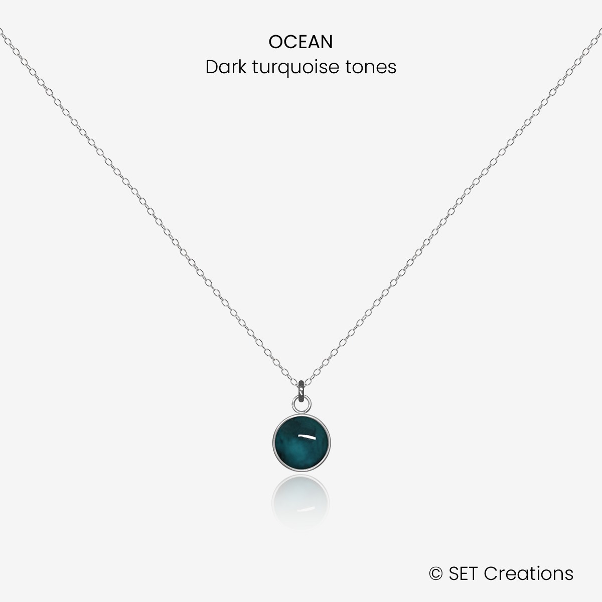 6mm fused glass circular cabochon set into a steel base and attached to a 400mm stainless steel pendant chain via jump ring. Cabochon colour: Ocean = deep turquoise and aqua marble effect.