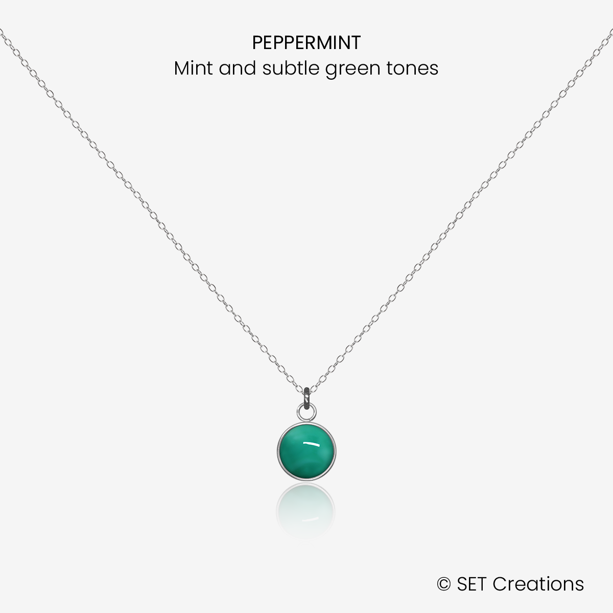 6mm fused glass circular cabochon set into a steel base and attached to a 400mm stainless steel pendant chain via jump ring. Cabochon colour: Peppermint = mint and subtle green marble effect.