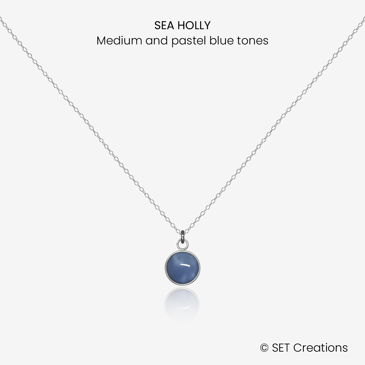 6mm fused glass circular cabochon set into a steel base and attached to a 400mm stainless steel pendant chain via jump ring. Cabochon colour: Sea Holly = medium and pastel blue marble effect.