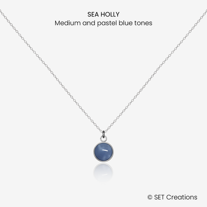 6mm fused glass circular cabochon set into a steel base and attached to a 400mm stainless steel pendant chain via jump ring. Cabochon colour: Sea Holly = medium and pastel blue marble effect.
