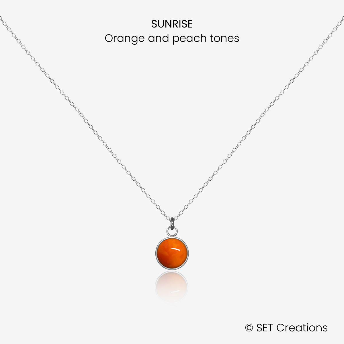 6mm fused glass circular cabochon set into a steel base and attached to a 400mm stainless steel pendant chain via jump ring. Cabochon colour: Sunrise = orange and deep red marble effect.