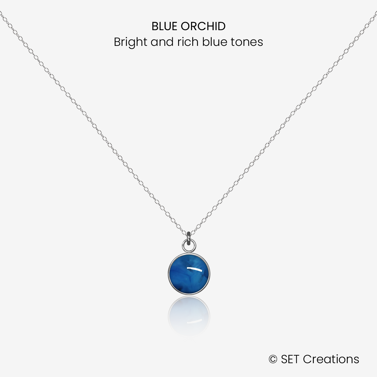 8mm fused glass circular cabochon set into a steel base and attached to a 500mm stainless steel pendant chain via jump ring. Cabochon colour: Blue Orchid = bright and rich blue marble effect.