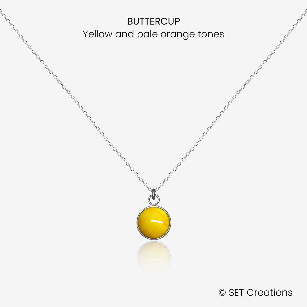 8mm fused glass circular cabochon set into a steel base and attached to a 500mm stainless steel pendant chain via jump ring. Cabochon colour: Buttercup = yellow and pale orange marble effect.