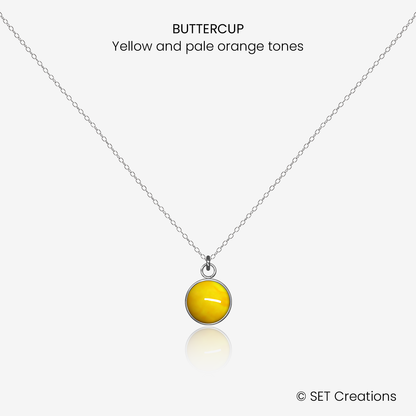 8mm fused glass circular cabochon set into a steel base and attached to a 500mm stainless steel pendant chain via jump ring. Cabochon colour: Buttercup = yellow and pale orange marble effect.