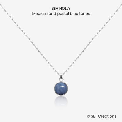 8mm fused glass circular cabochon set into a steel base and attached to a 500mm stainless steel pendant chain via jump ring. Cabochon colour: Sea Holly = medium and pastel blue marble effect.
