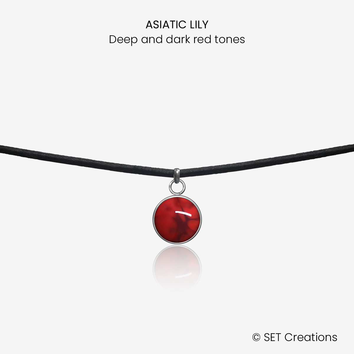 10mm fused glass circular cabochon set into a steel base and attached to a 380mm faux suede black cord via jump ring.  Cabochon colour: Asiatic Lily = deep and dark red marble effect.