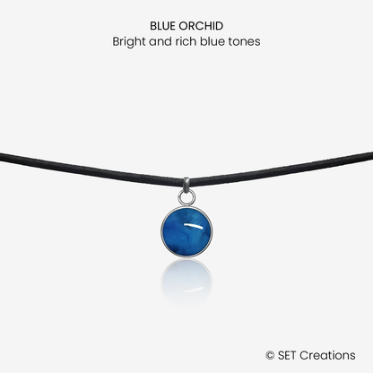 10mm fused glass circular cabochon set into a steel base and attached to a 380mm faux suede black cord via jump ring. Cabochon colour: Blue Orchid = bright and rich blue marble effect.