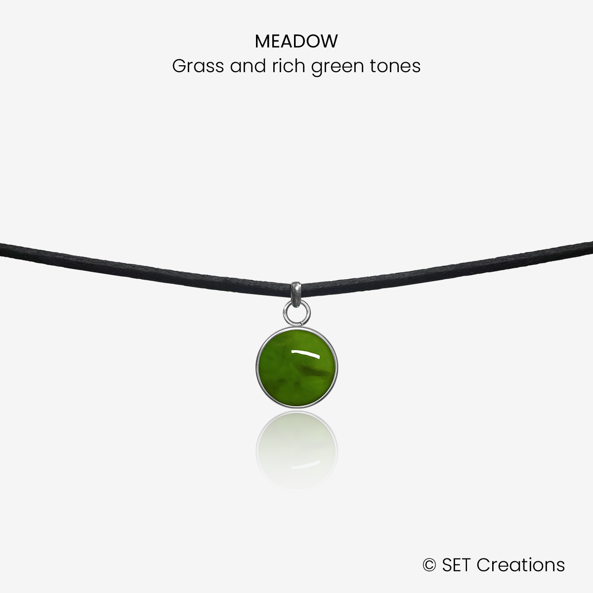 10mm fused glass circular cabochon set into a steel base and attached to a 380mm faux suede black cord via jump ring. Cabochon colour: Meadow = grass and rich green marble effect.