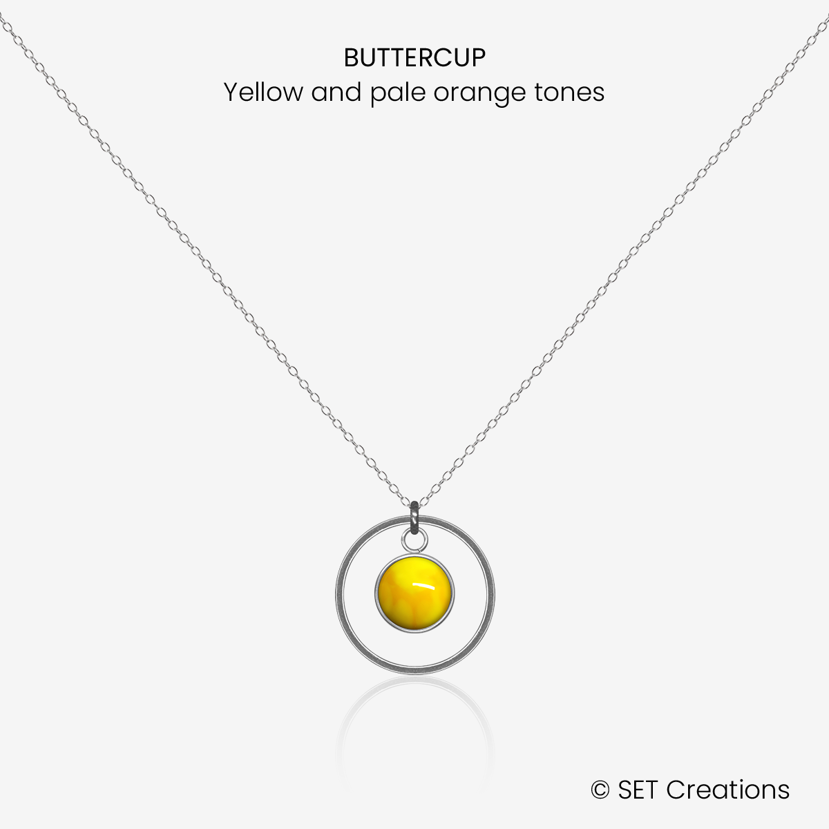 6mm fused glass circular cabochon set into a steel base, framed with a 16mm steel hoop and attached to a 400mm stainless steel pendant chain via jump ring. Cabochon colour: Buttercup = yellow and pale orange marble effect.