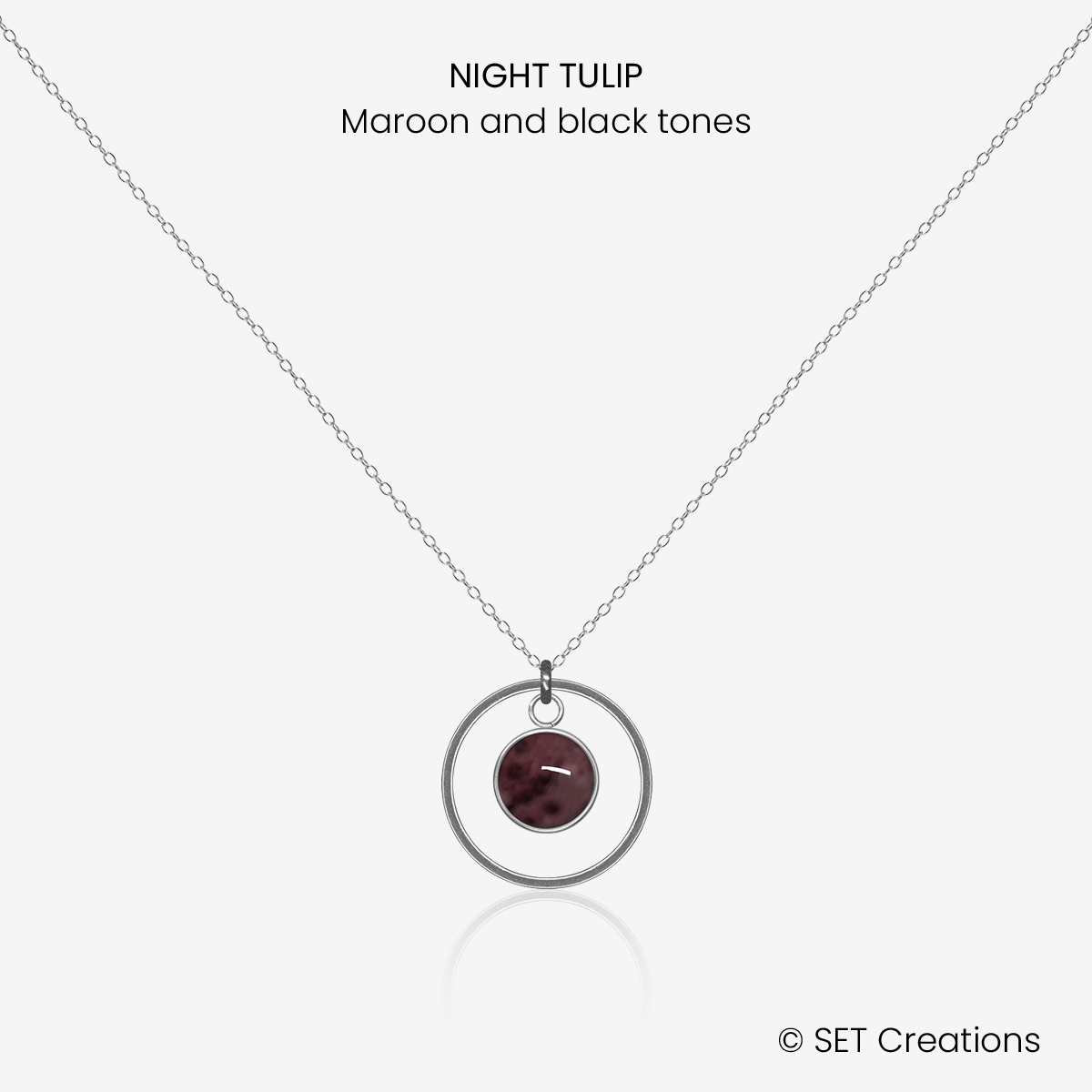 6mm fused glass circular cabochon set into a steel base, framed with a 16mm steel hoop and attached to a 400mm stainless steel pendant chain via jump ring. Cabochon colour: Night Tulip = maroon and black marble effect.