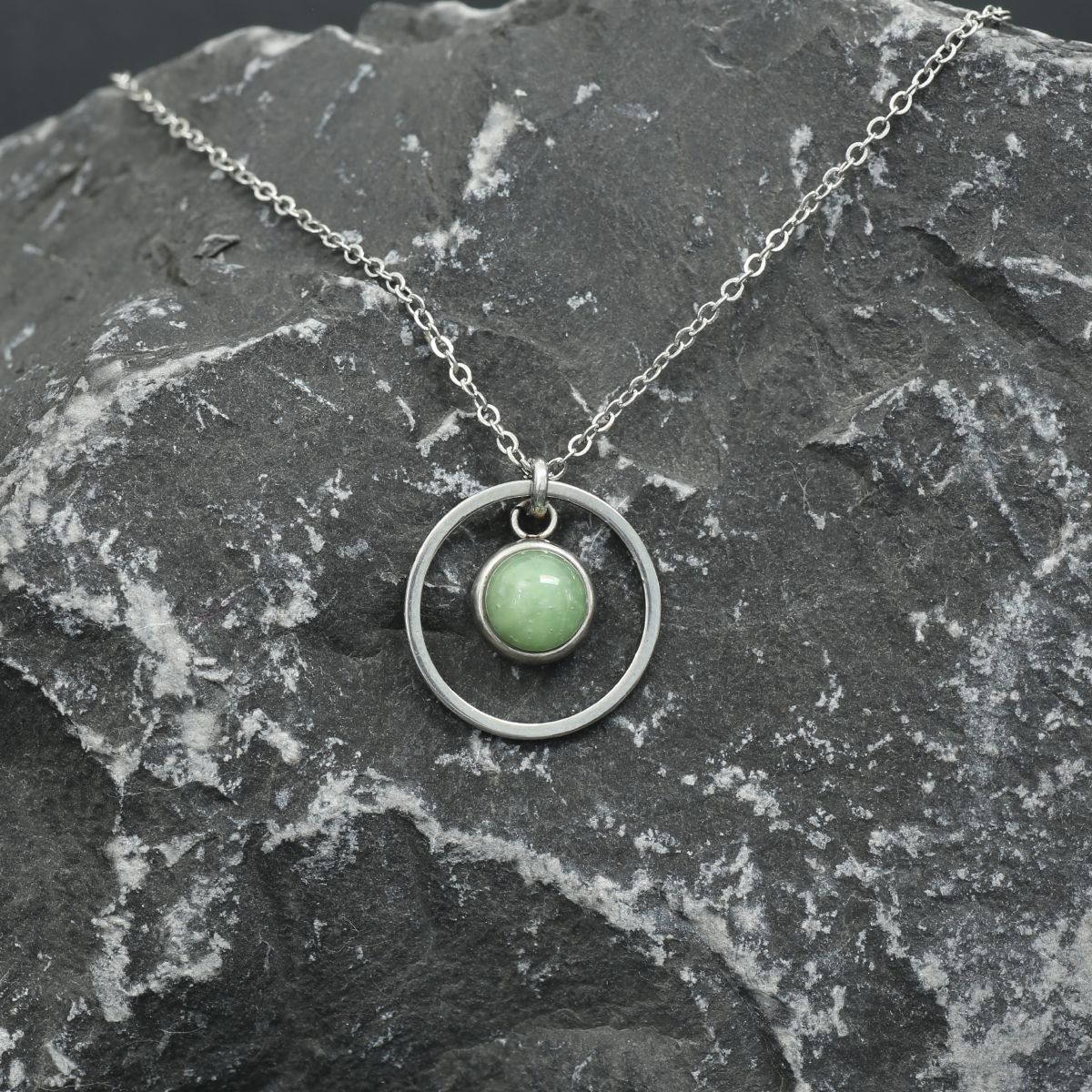 6mm fused glass circular cabochon set into a steel base, framed with a 16mm steel hoop and attached to a 400mm stainless steel pendant chain via jump ring. Cabochon colour: Olive = pale and subtle green marble effect.
