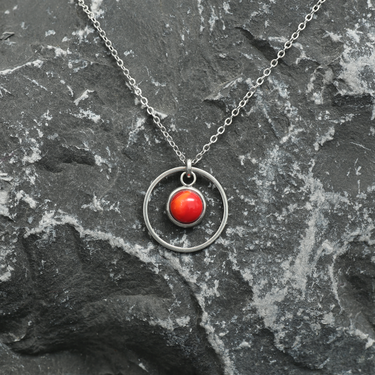 6mm fused glass circular cabochon set into a steel base, framed with a 16mm steel hoop and attached to a 400mm stainless steel pendant chain via jump ring. Cabochon colour: Wild Poppy = bright and mid red marble effect.