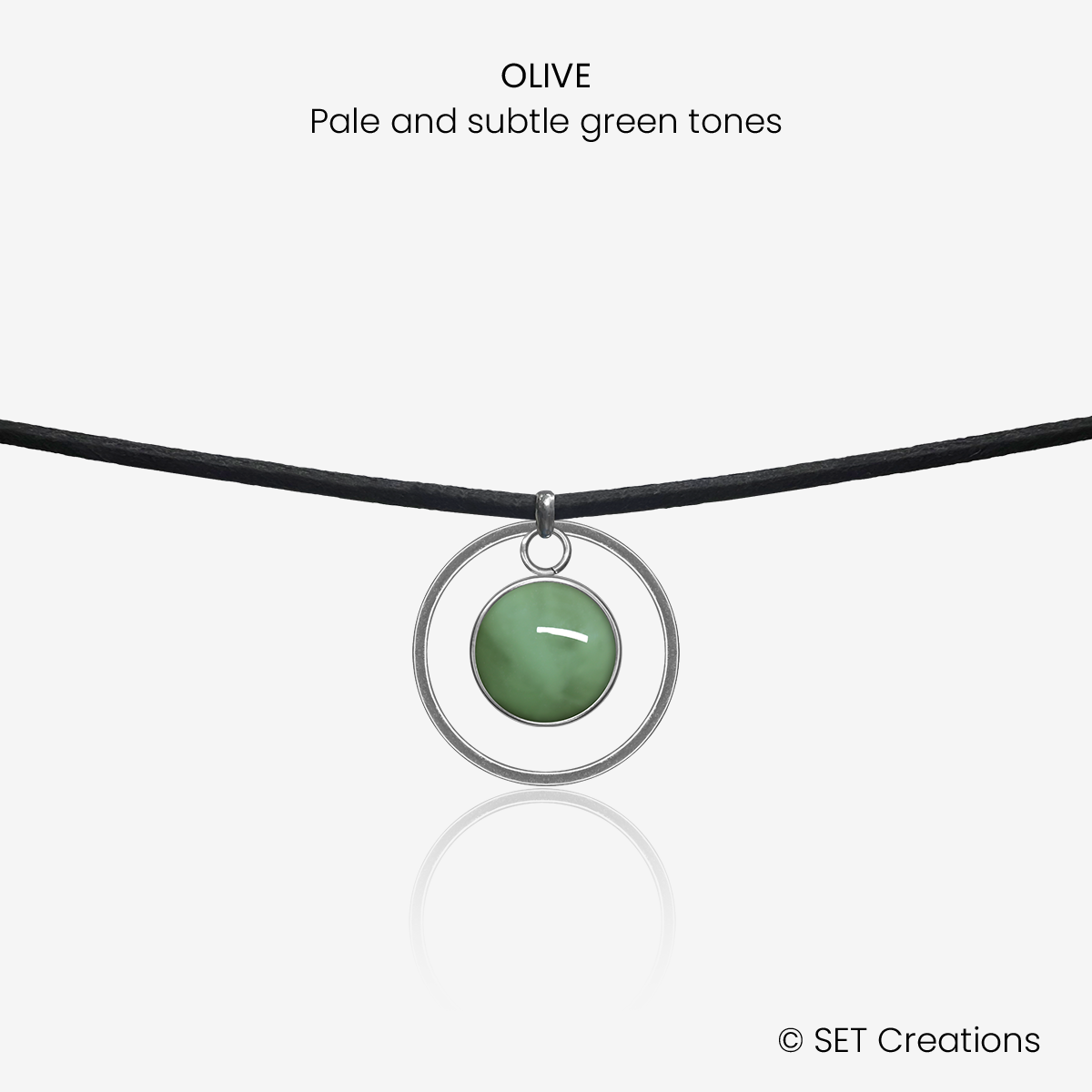 10mm fused glass circular cabochon set into a steel base, framed with a 20mm steel hoop and attached to a 380mm faux suede black cord via jump ring. Cabochon colour: Olive = pale and subtle green marble effect.