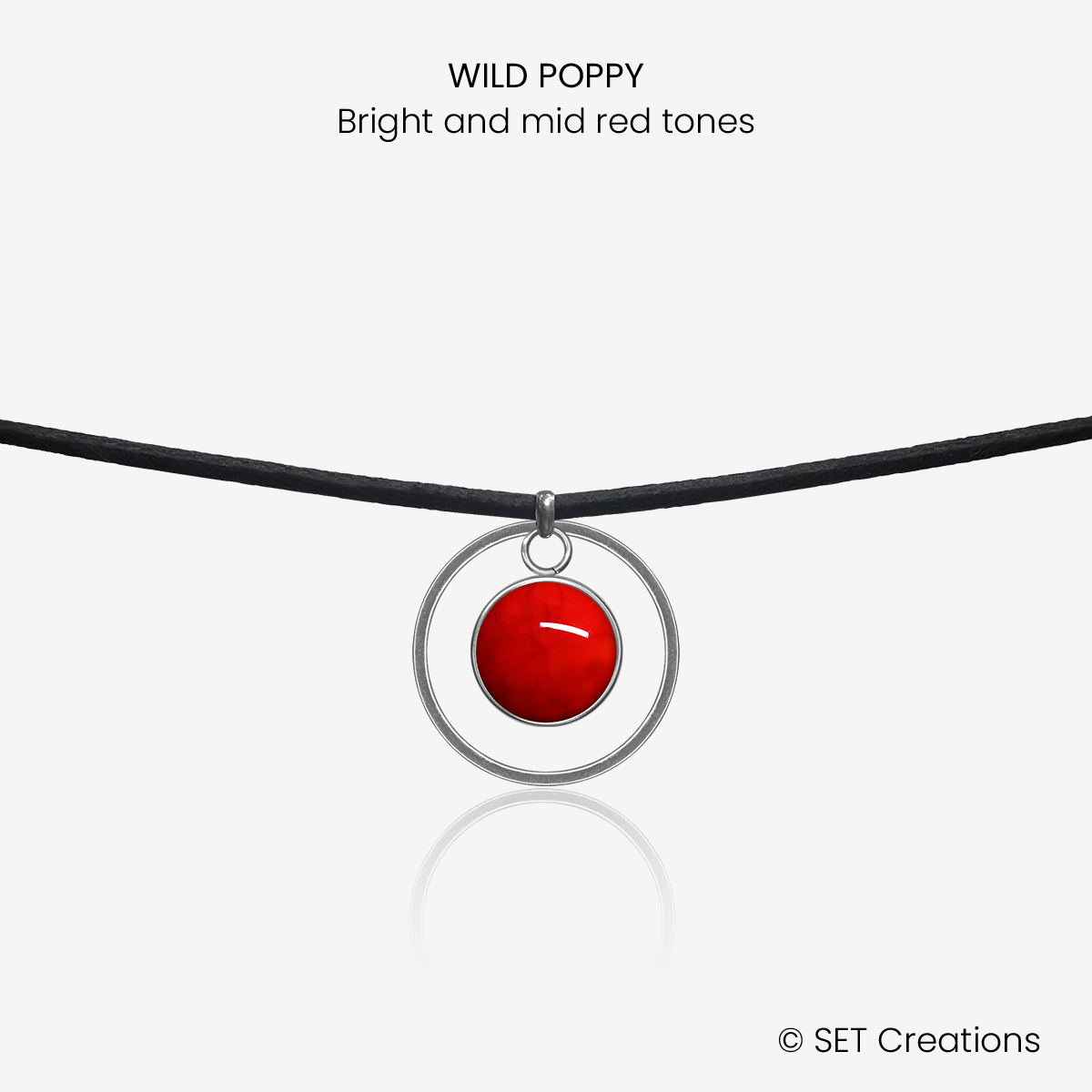 10mm fused glass circular cabochon set into a steel base, framed with a 20mm steel hoop and attached to a 380mm faux suede black cord via jump ring. Cabochon colour: Wild Poppy = bright and mid red marble effect.