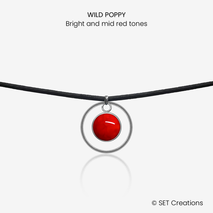 10mm fused glass circular cabochon set into a steel base, framed with a 20mm steel hoop and attached to a 380mm faux suede black cord via jump ring. Cabochon colour: Wild Poppy = bright and mid red marble effect.