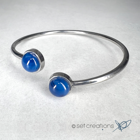 2 x 8mm fused glass circular cabochons set into stainless steel adjustable 2mm thick wire bangles. Cabochon colour: Blue Orchid = bright and rich blue marble effect.